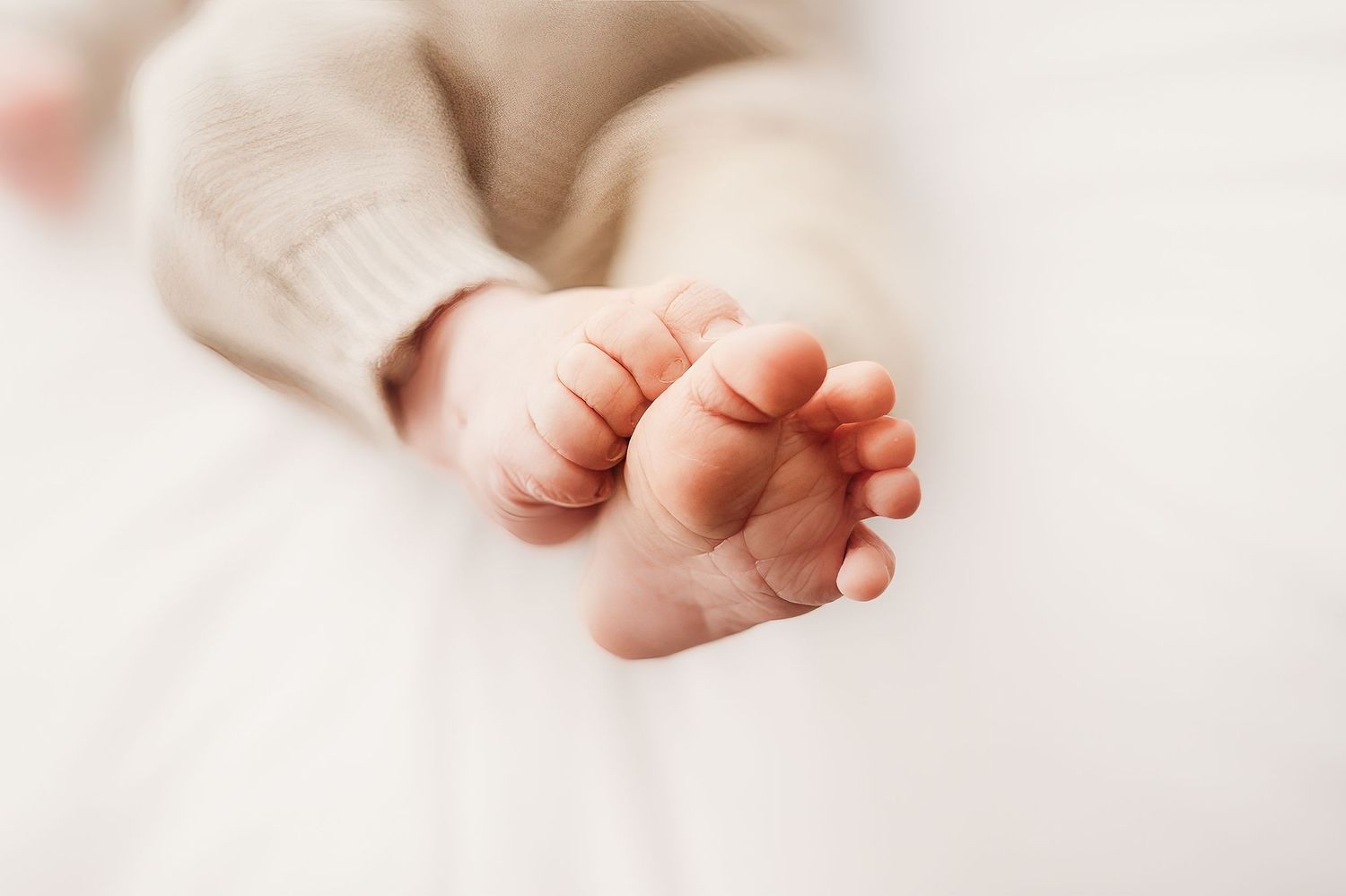 Close-up detail shots of tiny baby feet against white background.