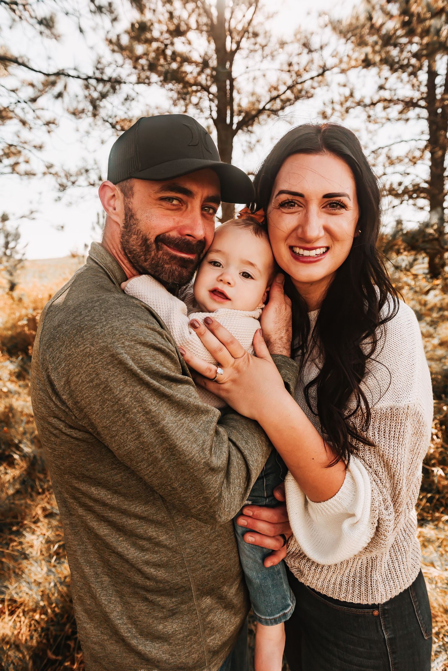 Joyful family shares tender moments and laughter during outdoor autumn photoshoot.